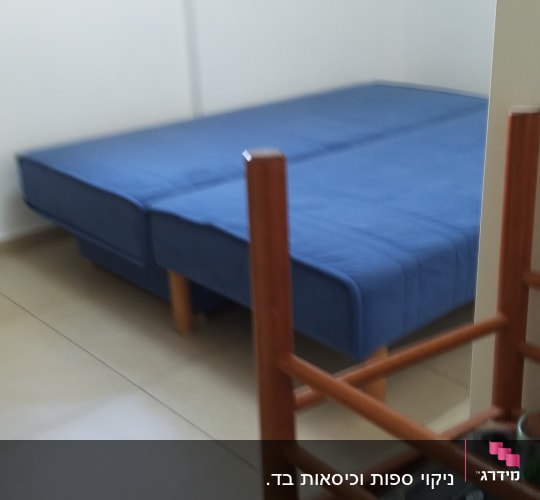ספה כחולה בחדר עם רצפת אריחים